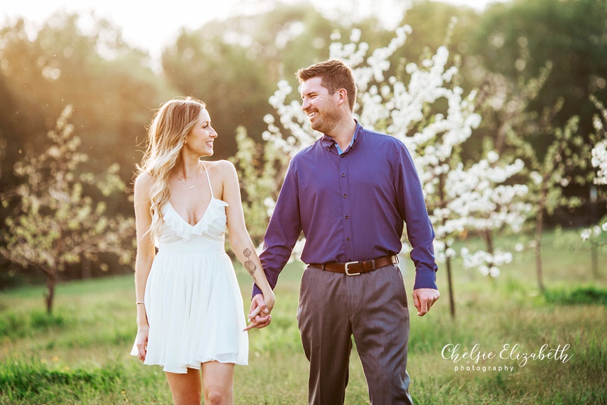 couple walking in an apple orchard