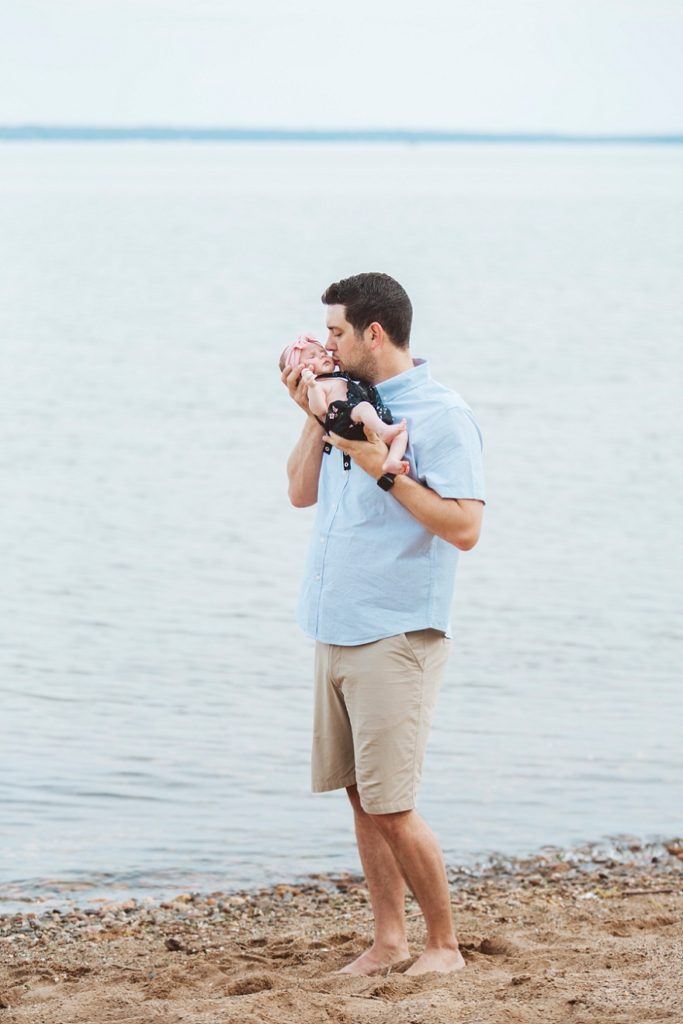 dad and newborn on beach