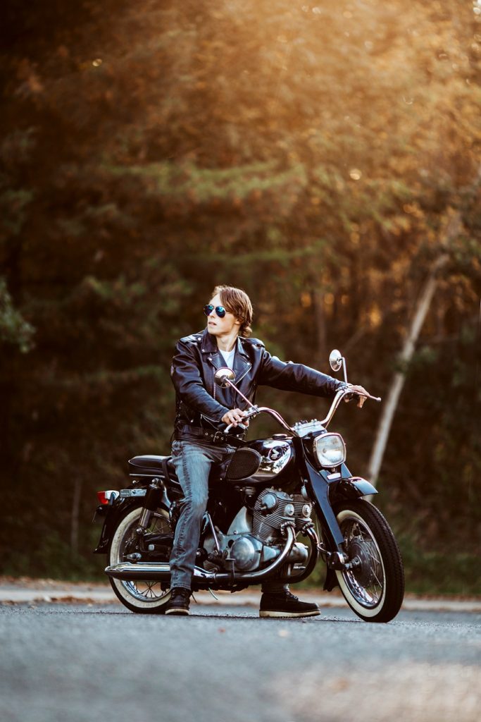 senior guy on motorcycle at sunset