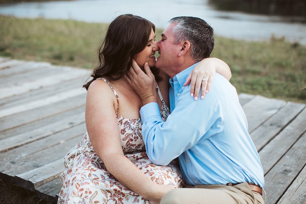 man and woman kissing on bridge