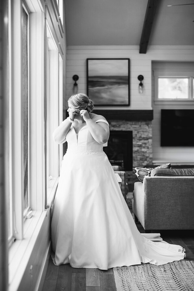 Black and white image of bride at window