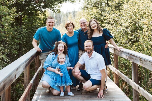 Family vacationing at Boyd Lodge in Crosslake MN.  The family is posed together on the foot bridge leading to whitefish lake