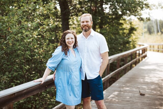 husband and wife posing for a portrait on the foot bridge at Boyd Lodge in Crosslake MN