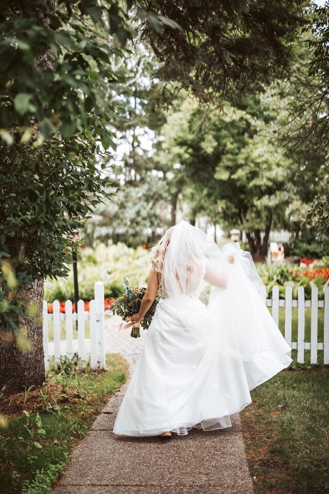 a lovely image of a bride in a garden setting on her wedding day in Nisswa MN