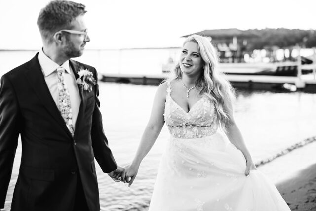 a black and white photo of a bride and groom on the beach at Grand View Lodge